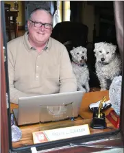  ??  ?? Trevis Gleason at home with his Wheaten terriers at the window seat where he does his writing.