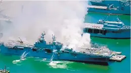  ?? KGTV-TV ?? Crews fight a fire aboard the USS Bonhomme Richard at Naval Base San Diego on Sunday. Seventeen sailors and four civilians were injured. People in the area reported an explosion early Sunday.