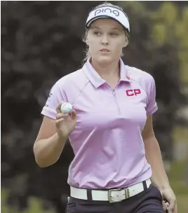  ?? AP PHOTO ?? ON THE CUSP: Leader Brooke Henderson waves after making a putt at the ninth green during yesterday’s third round of the LPGA Marathon Classic in Sylvania, Ohio.