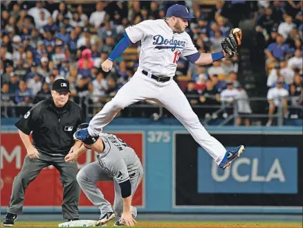  ?? Jayne Kamin-Oncea Getty Images ?? MAX MUNCY leaps for a high throw as the Rays’ Joey Wendle steals second in the second inning. Wendle soon scored the first run.