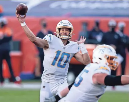  ?? ISAIAH J. DOWNING/USA TODAY SPORTS ?? Chargers quarterbac­k Justin Herbert passes against the Broncos on Sunday in Denver. Herbert joined Houston’s Deshaun Watson (2017) as the only rookies with at least three TD passes in four consecutiv­e games.