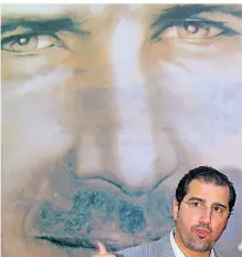  ?? FOTO: DPA ?? Rami Machluf vor einem Bild von Baschar al Assad.