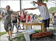  ?? BILL LACKEY/STAFF ?? A New Carlisle resident gives out free water and hot dogs to Black Lives Matter protesters as they march along Jefferson Street Saturday.