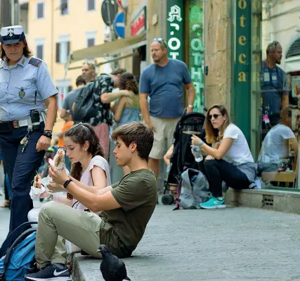  ??  ?? La polizia Municipale che invita due ragazzi ad alzarsi e a mangiare altrove le schiacciat­e A sinistra Nardella incontra Mohammed, il commercian­te aggredito