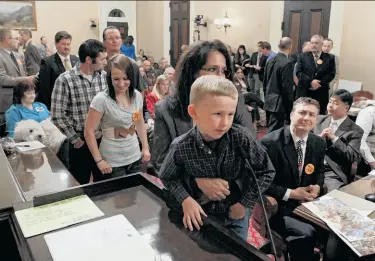  ?? Rich Pedroncell­i / Associated Press ?? Trace Conard, 5, of Corning is held up by his mother as he urges lawmakers to vote against the ban.