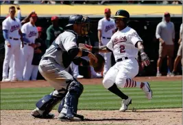  ?? ASSOCIATED PRESS ?? OAKLAND ATHLETICS’ KHRIS DAVIS (2) scores a run against San Diego Padres catcher A.J. Ellis during the eighth inning of Wednesday’s game in Oakland, Calif.