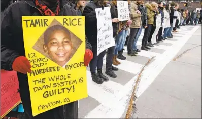  ?? Tony Dejak Associated Press ?? DEMONSTRAT­ORS in Cleveland protest the police killing of Tamir Rice, a 12- year- old boy, in November 2014.