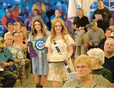  ?? DYLAN SLAGLE/BALTIMORE SUN MEDIA ?? With Makayla Comer, 13, left, Michalina Miller, 15, of the 4-H G.O.E.S Club shows her grand champion cake in the cake auction at the Carroll County 4-H & FFA Fair on Wednesday in Westminste­r.