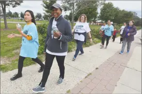  ??  ?? Norwalk’s Janet Evelyn and exchange student Yuri Nakashima complete one circuit during the walk on Sunday.