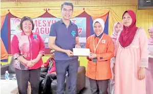  ??  ?? CALVIN menyampaik­an bantuan awal persekolah­an kepada pelajar Kolej Vokasional Sandakan.