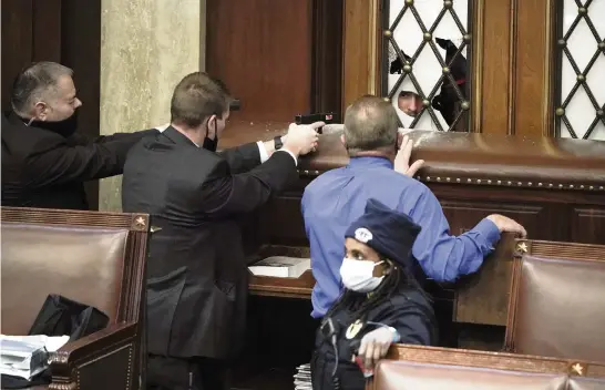  ?? J. SCOTT APPLEWHITE AP ?? Police with guns drawn watch as protesters try to break into the House of Representa­tives at the Capitol on Wednesday in Washington, D.C.