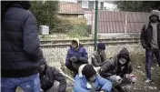  ?? CHRISTOPHE ENA AP ?? Migrants wait for food distributi­on at a camp in Calais, northern France, on Oct. 14. The price to cross the English Channel varies according to the network of smugglers, between 3,000 and 7,000 euros. Often, the fee also includes a very short-term tent rental in the windy dunes of northern France and food cooked over fires that sputter in the rain that falls for more than half the month of November in the Calais region.