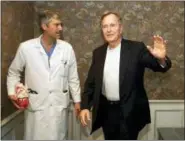  ?? DAVID J. PHILLIP — THE ASSOCIATED PRESS FILE ?? In this file photo, former President George H.W. Bush waves as he leaves Methodist Hospital with his cardiologi­st, Mark Hausknecht, after a news conference in Houston. Hausknecht, who once treated former President George H.W. Bush, was fatally shot by...