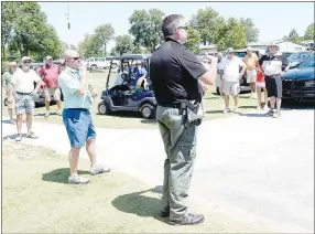  ??  ?? Decatur police chief Steve Grizzle (center) gives participan­ts last-minute instructio­ns before the shotgun start of the tournament. Murray (center left) waits to hand out scorecards after Grizzle’s instructio­nal speech.