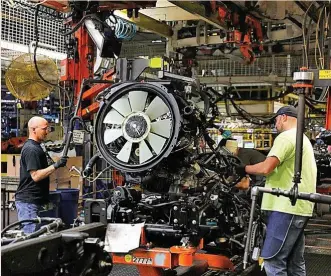  ?? ?? Empleados de General Motors en una cadena de ensamblaje en una planta en Flint, Michigan.