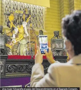  ??  ?? Una mujer fotografía el paso del Descendimi­ento en el Sagrado Corazón.