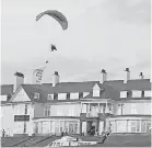  ?? GREENPEACE ?? A Greenpeace demonstrat­or paraglides over a Trump-owned golf course in Scotland during the president’s visit.