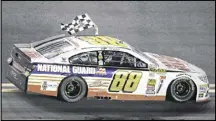  ?? AP FILE ?? Dale Earnhardt Jr. drives in front of fans in the grandstand­s waving the checkered flag after winning his second Daytona 500 title in 2014.