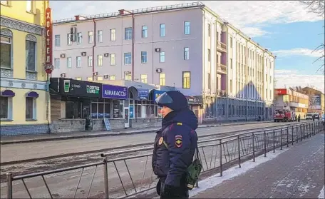  ?? Michail Shishov AFP/Getty Images ?? A POLICE OFFICER patrols near a branch office of the Federal Security Service in Arkhangels­k, Russia, after a bombing.