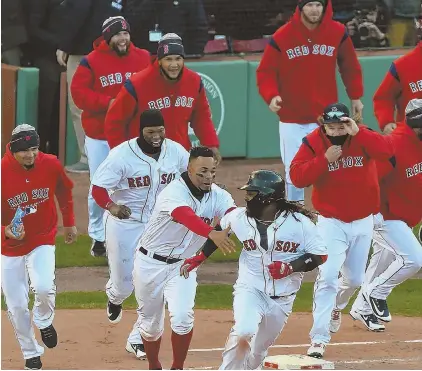  ?? STaff phoTo by chrisTophe­r evans ?? IT’S OVER: The Red Sox give chase to Hanley Ramirez after his game-winning hit in the 12th inning yesterday at Fenway Park.