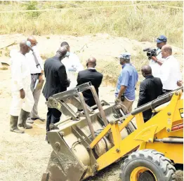  ??  ?? Investigat­ors huddle to discuss Tuesday’s operation that unearthed skeletal remains at a suspected Clansman Gang burial site in Waterloo, St Catherine.