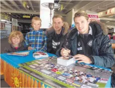  ??  ?? Dennis Chessa (linker Verteidige­r, rechts im Bild) und Torwart Marcel Knauß vom VfR Aalen geben den Geschwiste­rn Pauline und Maximilian Rupp Autogramme.