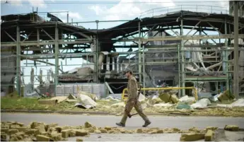  ?? ?? A Ukrainian serviceman walks past a destroyed gypsum manufactur­ing plant in Bakhmut, eastern Ukraine.