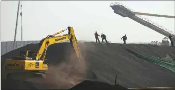  ??  ?? Labourers work on a pile of iron ore at a steel factory in Tangshan, China (file). The global iron ore market has become more fragmented over the past three years, with greater demand for higher-quality material and wider spreads between grades by content and purity.