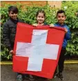  ?? Foto: Susanne Rummel ?? Ahmad, Sueda und Sahwan (von links) mit der Flagge unseres Nachbarlan­des Schweiz.