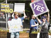  ?? JEFF J. MITCHELL / GETTY IMAGES ?? People hold “Yes” placards Friday on Fairview Road in Dublin, as Ireland voted on whether or not to abolish a constituti­onal amendment that makes abortions illegal.