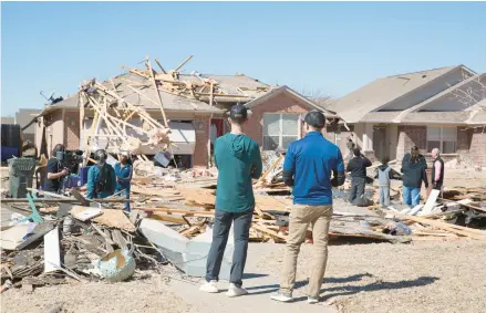  ?? ALONZO ADAMS/AP ?? Residents survey storm damage to homes in their neighborho­od Monday in Norman, Okla.