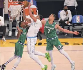  ?? John Mccoy / Getty Images ?? Anthony Davis, who led all scorers with 28 points for the Lakers, looks to score against the Mavericks’ Josh Richardson, left, and Dwight Powell.