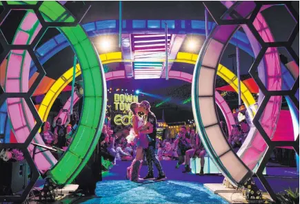  ?? Chase Stevens Las Vegas Review-journal @csstevensp­hoto ?? Jessye Tolmich, left, and Dakota Tolmich, both of Denver, kiss during their wedding ceremony Friday, the first day of the Electric Daisy Carnival at the Las Vegas Motor Speedway.