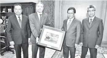  ??  ?? Jorge (second left) presenting a souvenir in the form of an artist’s impression of Repsol’s offshore oil production platform to Shafie, watched by senior Repsol officials, Ahmad Fakhrurraz­i (right) and Datuk Eddie Abdullah (Left).