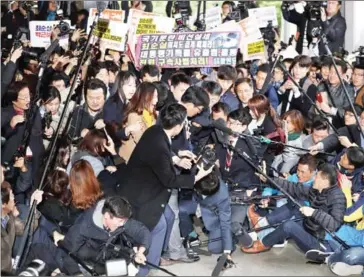  ?? YONHAP/AFP ?? Choi Soon-sil (centre) is surrounded by the media as she arrives at the Seoul Central District Prosecutor­s’ Office in Seoul yesterday.