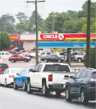  ?? SEAN RAYFORD / GETTY IMAGES ?? Motorists wait in line to refuel Wednesday at a Circle K gas station in Fayettevil­le, N.C.,
as most stations in the area along I-95 were without fuel.