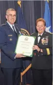  ?? U.S. STRATEGIC COMMAND, STEVE CUNNINGHAM ?? Air Force General John E. Hyten presents Maj. Gen. Heidi Brown with a certificat­e of retirement Friday at Offutt Air Force Base in Nebraska.