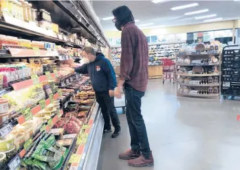  ?? DANIA MAXWELL/LOS ANGELES TIMES ?? An employee assists Will Butler, who is legally blind, on Jan. 31 at a California grocery store.