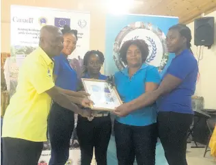  ??  ?? The all-female team from Grantham, seen here with project extension officer at the Environmen­tal Health Foundation, Andrew Carty, beat the males from Top Alston to emerge winners of the Upper Clarendon Farmers Climate Change Quiz competitio­n, which saw eight community teams competing for prizes.