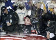  ?? JOHN RAOUX — THE ASSOCIATED PRESS ?? Harrison Burton, center, celebrates with crew members in Victory Lane after winning the ARCA series race at Daytona Internatio­nal Speedway on Saturday.