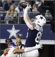  ?? (AP/Michael Ainsworth) ?? Dallas Cowboys tight end Dalton Schultz (right) catches a pass for one of his two third-quarter touchdowns as New York Giants cornerback Nick McCloud defends Thursday in Arlington, Texas. The Cowboys won 28-20, ending their three-game losing streak on Thanksgivi­ng.