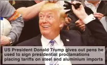  ??  ?? US President Donald Trump gives out pens he used to sign presidenti­al proclamati­ons placing tariffs on steel and aluminium imports