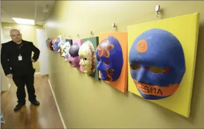  ??  ?? Dan Smith, a peer support counsellor at Good Shepherd’s Barrett Centre for Crisis Support, shows art therapy masks his clients made.