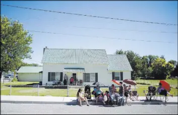  ?? BRIDGET BENNETT/LAS VEGAS REVIEW-JOURNAL / FOLLOW @BRIDGETKBE­NNETT ?? Residents shield themselves from the sun while lining the sidewalk for the Pioneer Day parade Saturday in Panaca. The annual celebratio­n in the tight-knit town came only 10 days after a bombing in which a 59-year-old man was killed and several families...