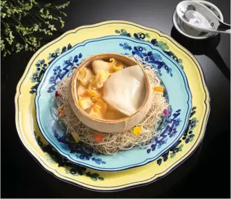  ??  ?? DOUBLE-BOILED SEA WHELK SOUP WITH FISH MAW AND CHICKEN SERVED IN A WHOLE COCONUT