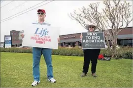  ?? Photograph­s by Katie Falkenberg Los Angeles Times ?? CHARLIE KAIN and Mary Borchard, with the 40 Days for Life group, protest in front of a Planned Parenthood health center in Plano, Texas.