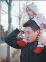  ?? PROVIDED TO CHINA DAILY ?? Zhao Heting, a photojourn­alist at Tencent News, with his 1-year-old daughter.