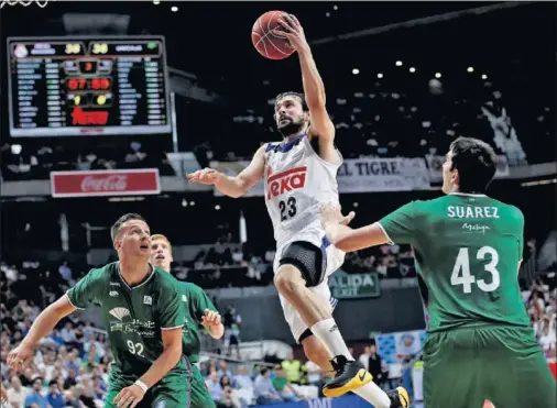  ??  ?? VUELA HACIA EL ARO. Sergio Llull rompe la defensa del Unicaja y se cuela hacia el aro entre Alen Omic y Carlos Suárez.