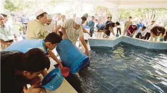  ??  ?? Pihak pengurusan menambah air yang disimpan bagi kegunaan orang ramai mengambil wuduk di Masjid Mu'adz Bin Jabal dekat Taman Setiawangs­a.