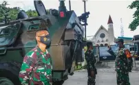  ?? RIANA SETIAWAN/JAWA POS ?? JAMIN KEAMANAN: Anggota TNI dilengkapi kendaraan taktis berjaga di sekitar Gereja Katolik Santo Yakobus saat misa Jumat Agung kemarin.